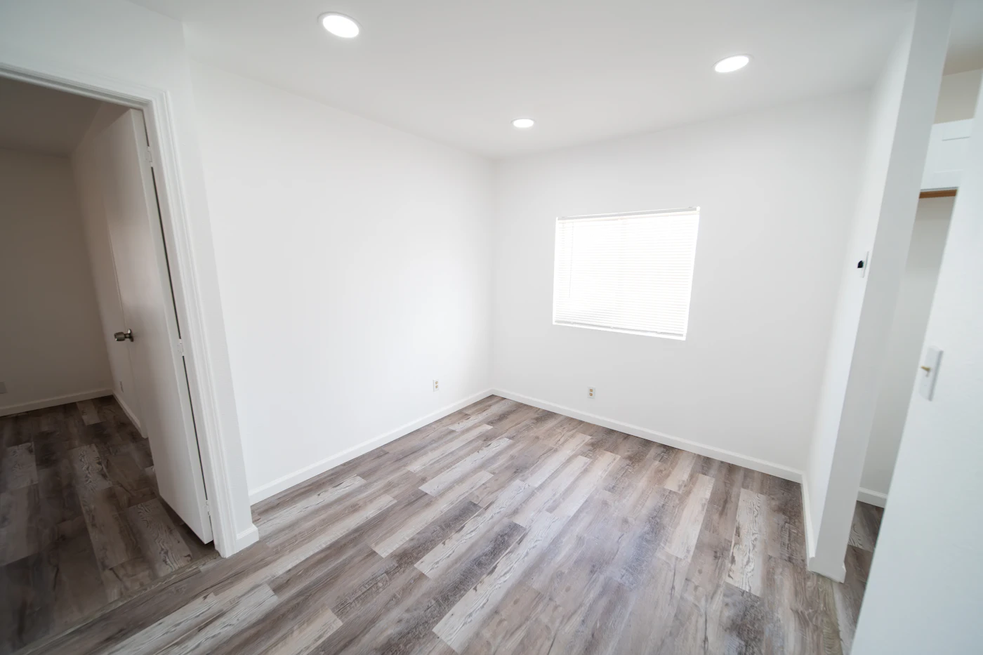 The finished basement laid wall to wall in pale oak look vinyl plank over a levelled floor