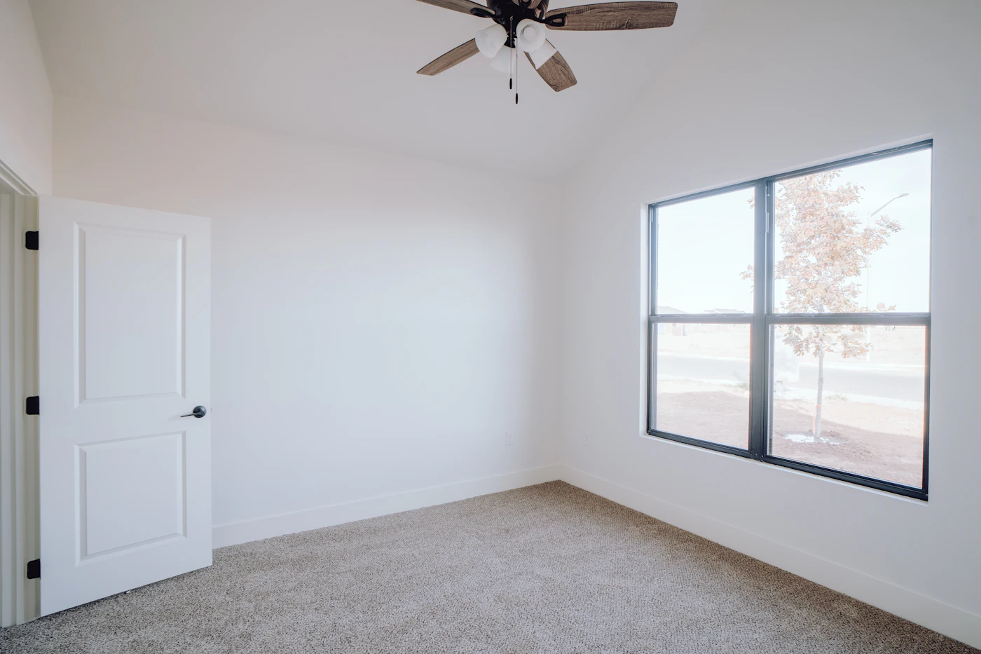 The same bedroom with fresh pale carpet laid wall to wall and clean edges at the baseboards
