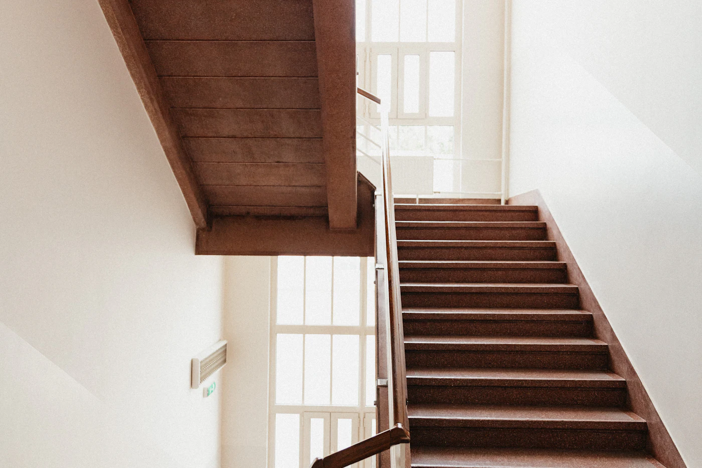 A bare wooden staircase with uncovered treads and white painted spindles, before any carpet was laid